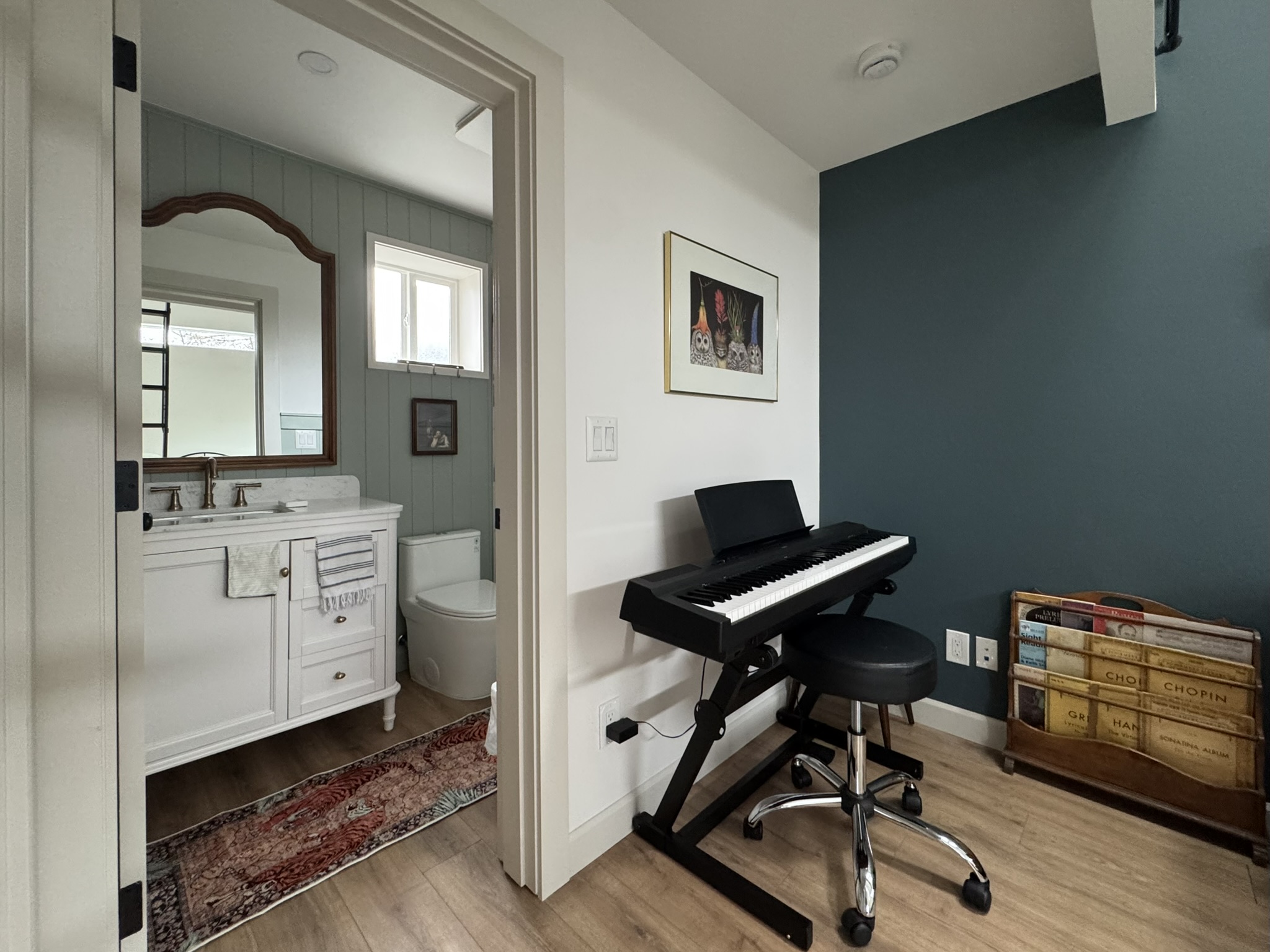 Interior view of the 262 sqft tiny house ADU in Kent, WA showing the bathroom entry next to an upright piano