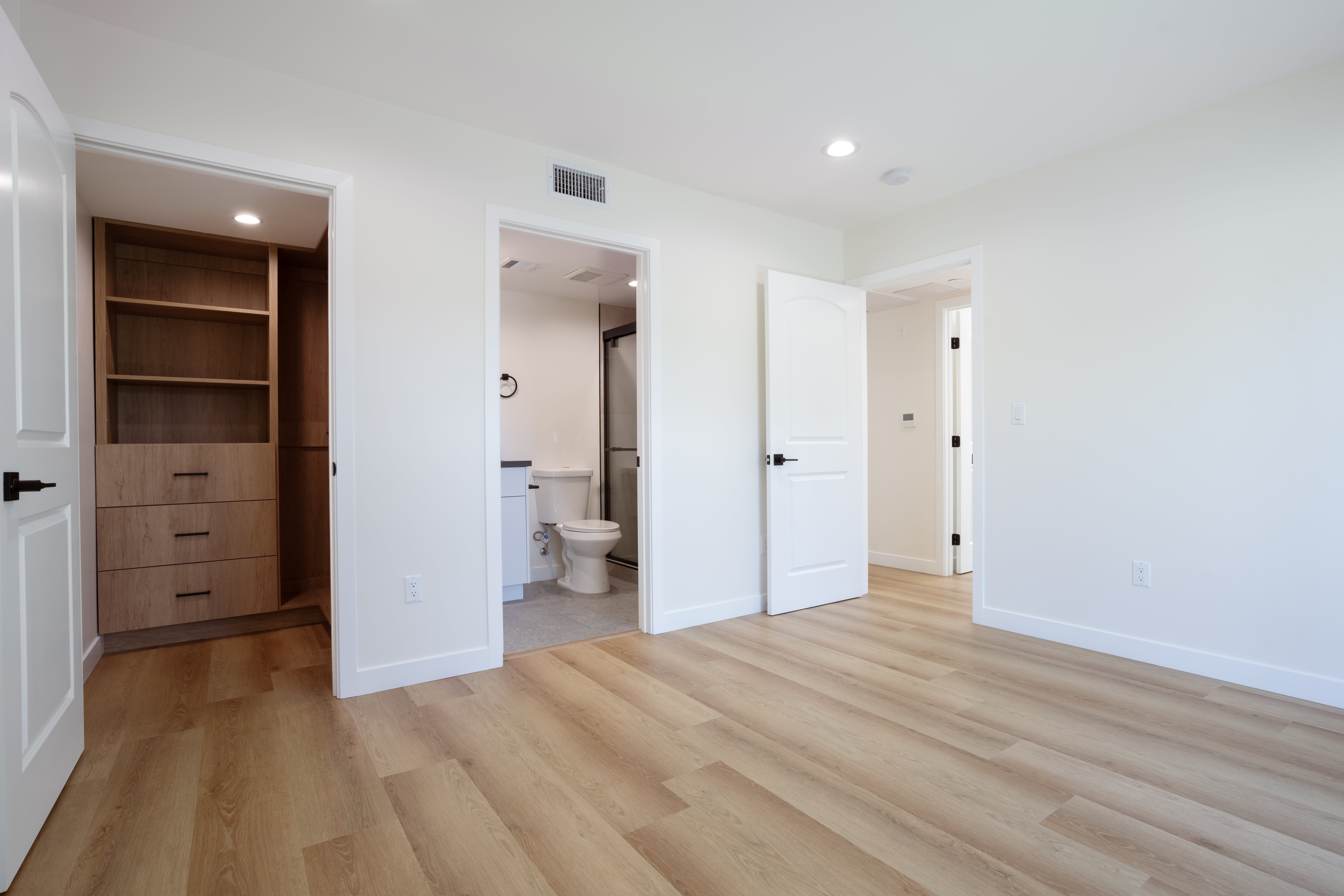 ADU bedroom with built-in closet storage, en-suite bathroom access, and modern finishes