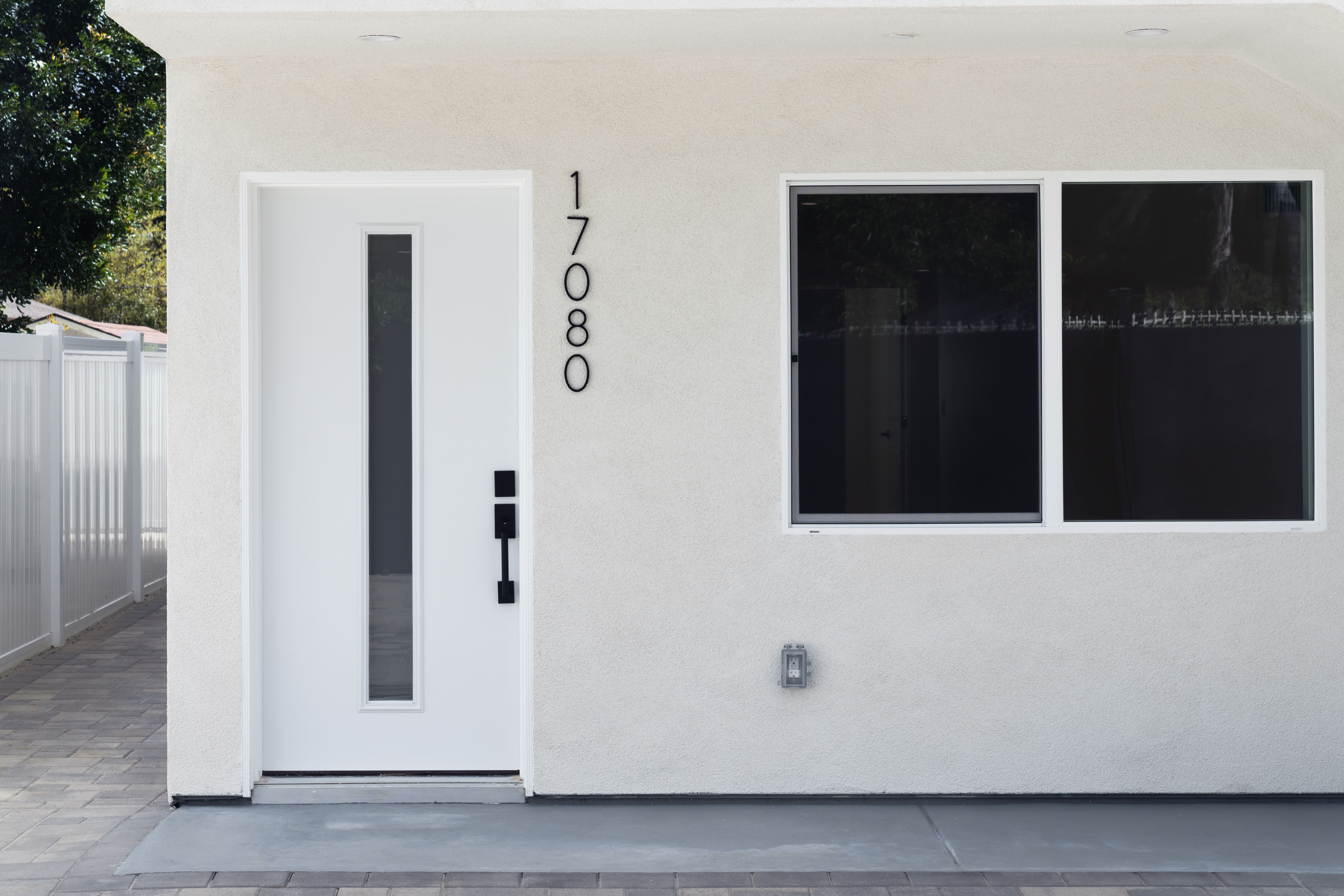 Modern ADU exterior with white stucco finish, contemporary front door, and clean architectural lines