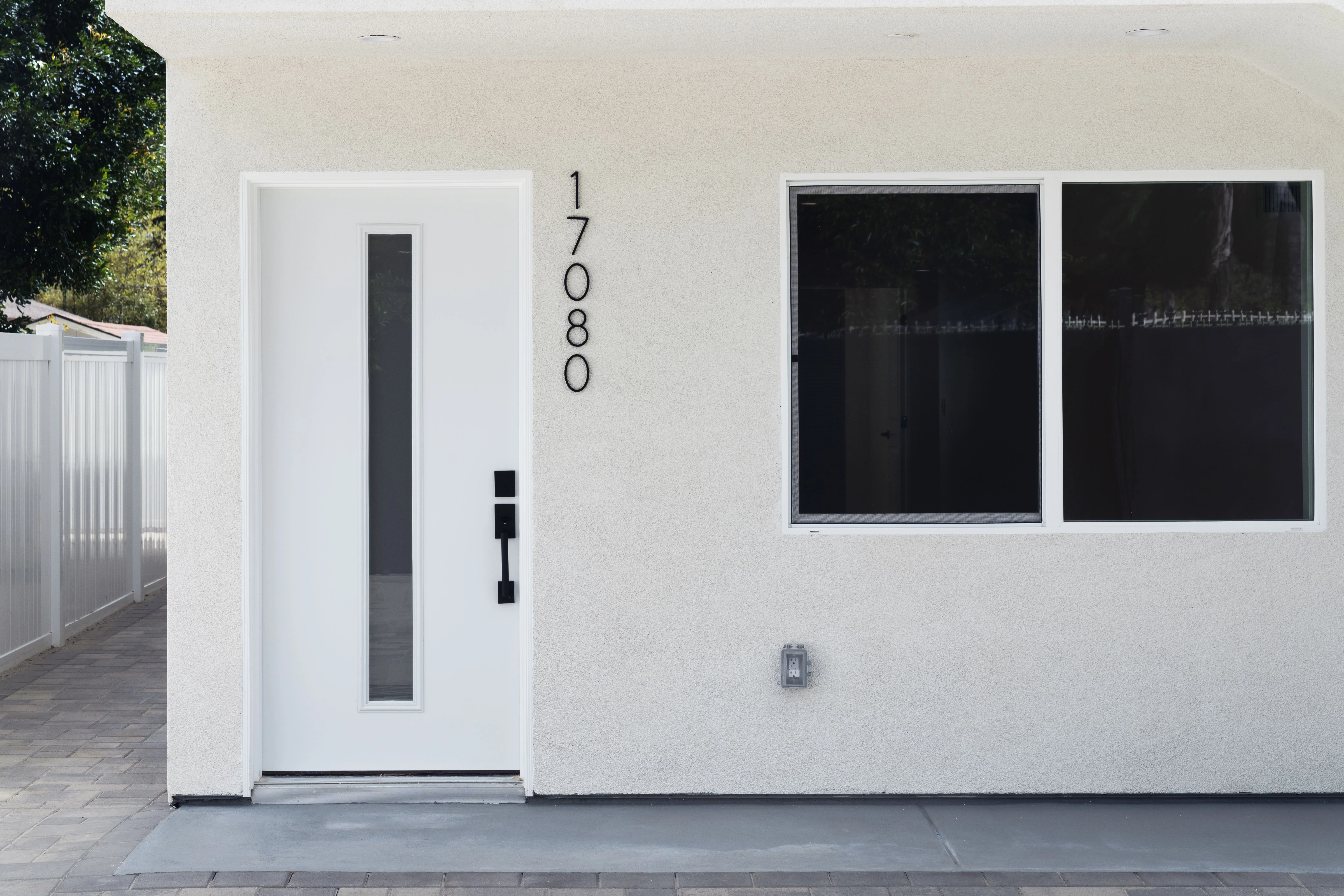 Modern ADU exterior with white stucco finish, contemporary front door, and clean architectural lines
